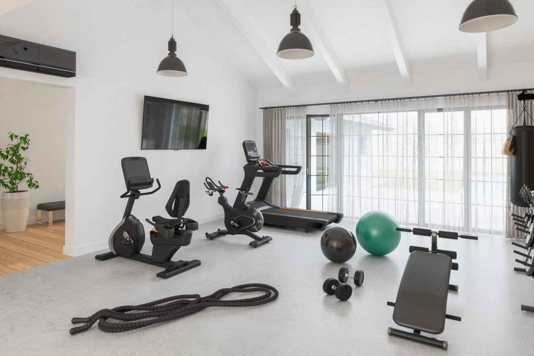 Home gym room featuring a variety of exercise equipment, set in a luxurious detached house.